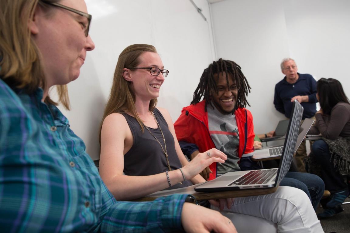 Students consulting a laptop